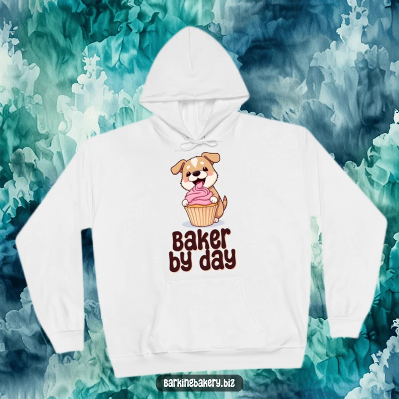 Funny dog hoodie showing a dog gleefully frosting a lopsided cupcake with a pink swirl, ideal for cozy bakers.