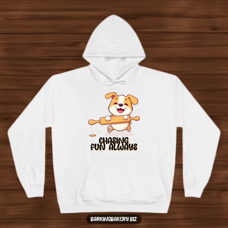 Funny Hoodie: A dog with a grin playfully chases a rolling pin, offering warmth and humorous baking-themed comfort.